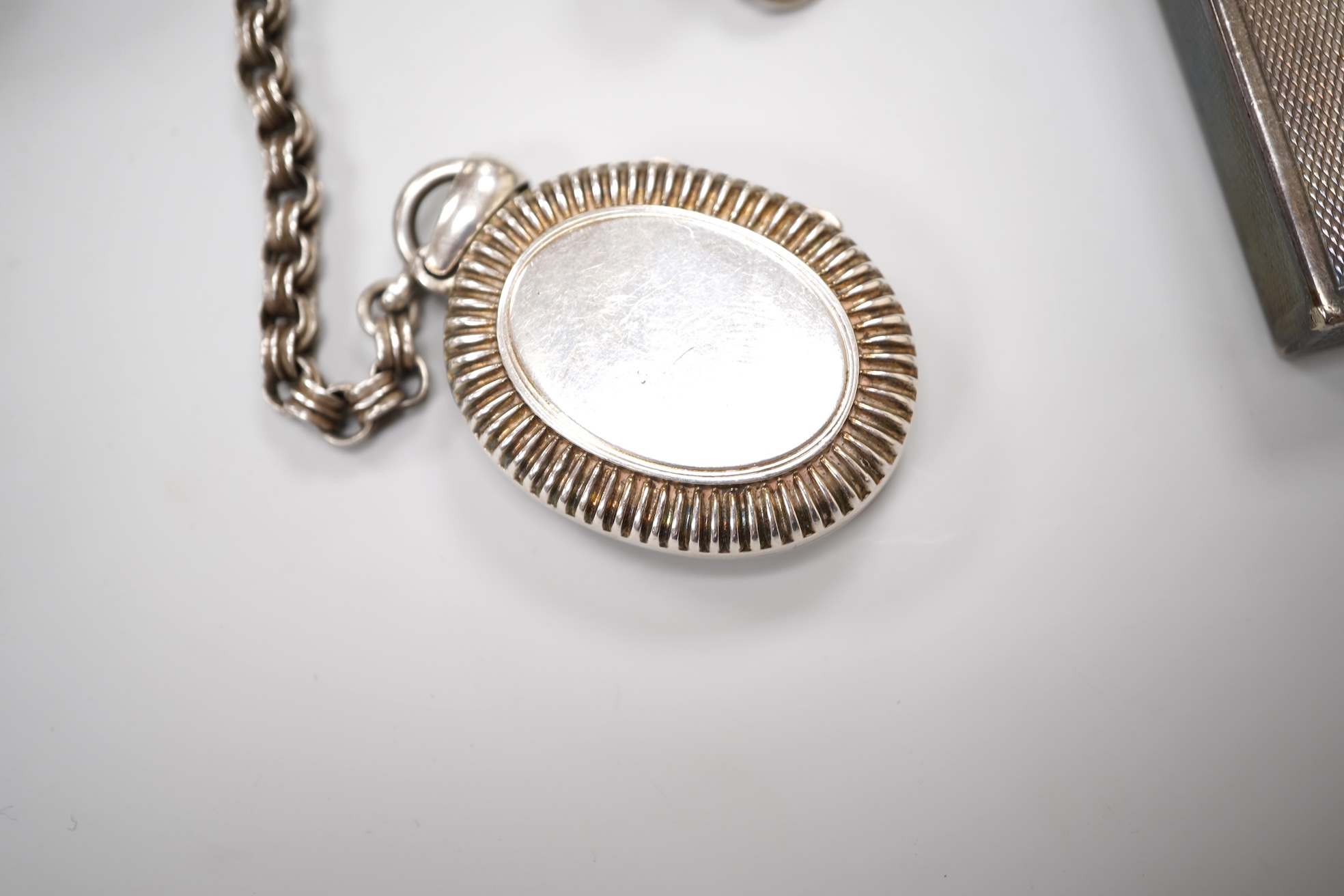 An early 20th century white metal oval locket, 40mm, on a silver chain, a silver plated Dunhill lighter, in Dunhill box, a white metal cased manual wind wrist watch and a tortoiseshell purse.